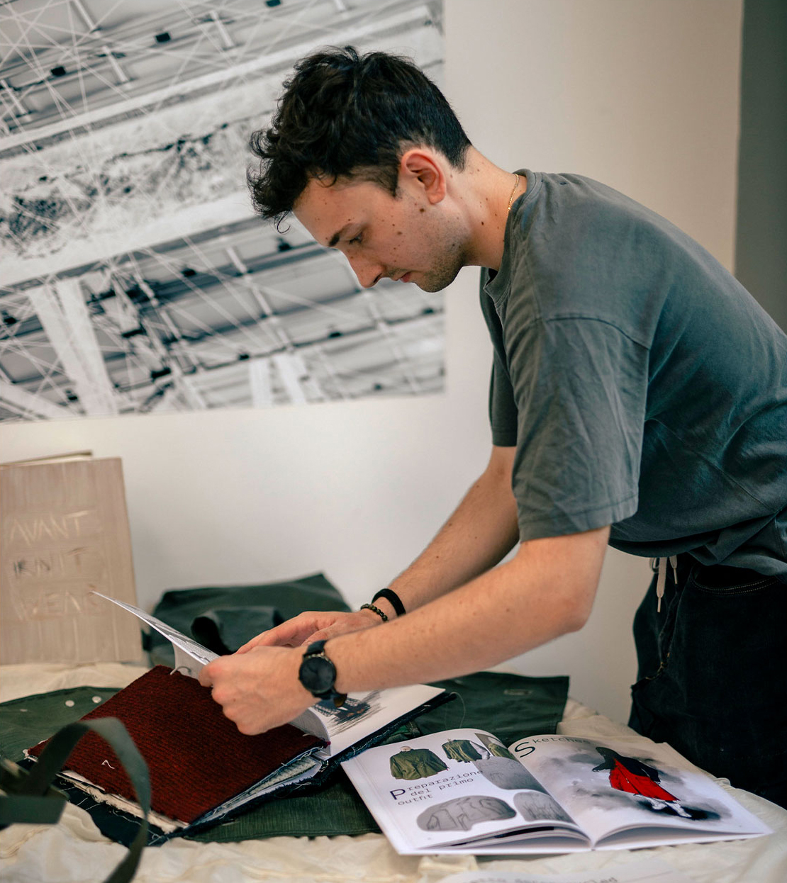 Studente a lavoro sull'allestimento espositivo di portfolio e progetti di fashion design.
